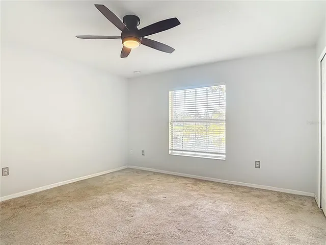 an empty room with a window and a fan