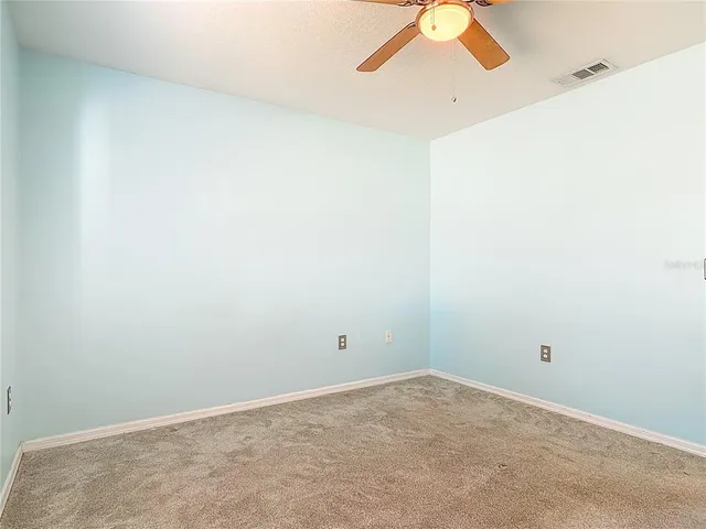 an empty room with a window and a ceiling fan