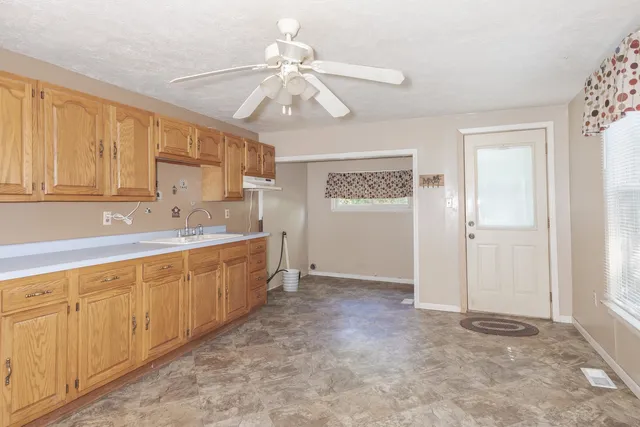 a view of a kitchen with refrigerator and cabinets