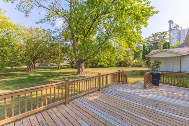 a front view of a house with a big yard and large trees