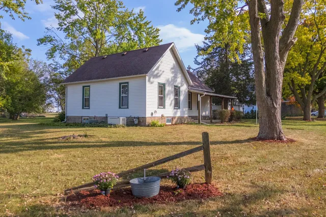 a view of a house with pool and trees in the background
