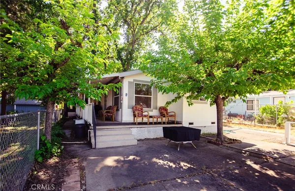 a view of a patio with table and chairs potted plants and large tree
