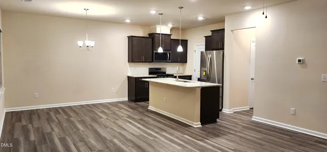 a kitchen with kitchen island a sink stove and refrigerator