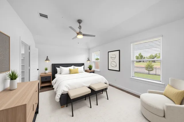 a spacious bedroom with a bed a couch and a window