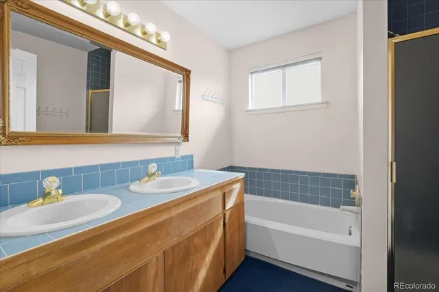 a bathroom with a tub sink and mirror