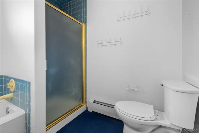 a white toilet sitting next to a shower