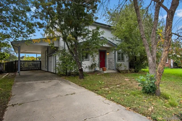 a view of a white house with a big yard and large tree
