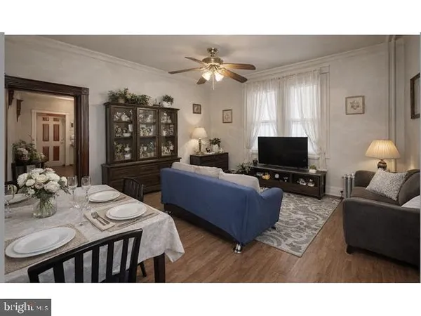 a living room with furniture a chandelier and a flat screen tv