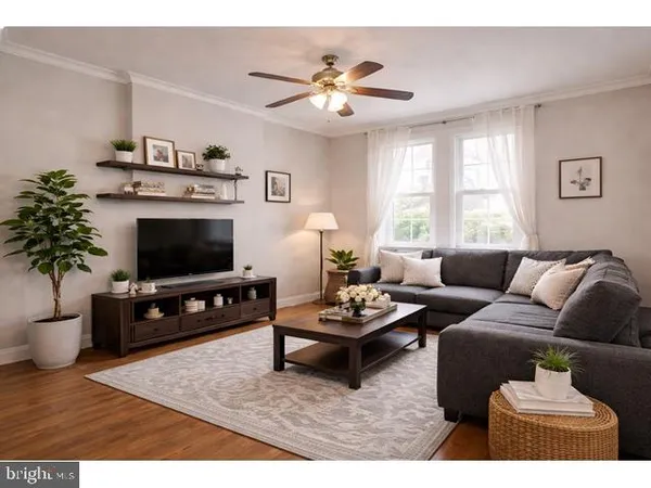 a living room with furniture a flat screen tv and a window