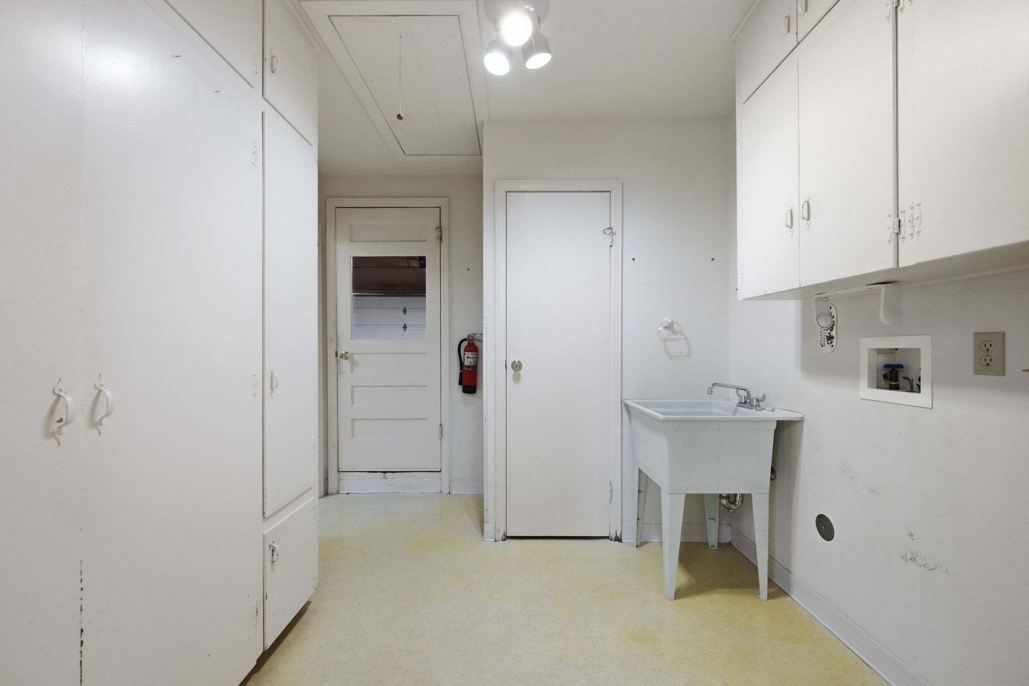 405 Ridgewood Road Austin, TX 78746 - Photo 19 of 32 The laundry room offers great storage options and a sink.