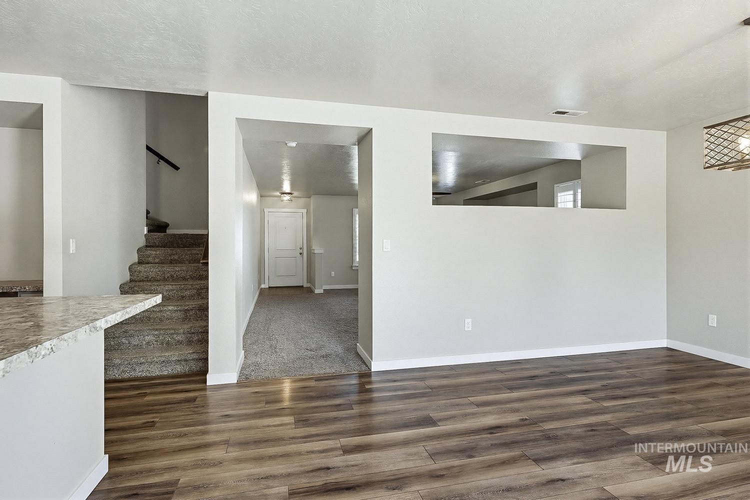 846 North Hidden View Way Star, ID 83669 - Photo 16 of 49 Open-concept living space with wood-finish flooring, a pass-through window, and a built-in light fixture