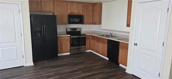 a kitchen with stainless steel appliances wooden floor a stove and a refrigerator