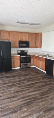a view of a kitchen with wooden cabinet and a refrigerator
