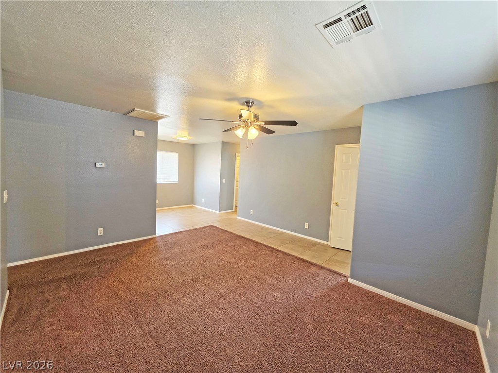 1444 Star Road, Unit 3 Pahrump, NV 89048 - Photo 8 of 35 A versatile living area features plush carpeting and durable tile flooring, creating distinct zones for comfort and activity.