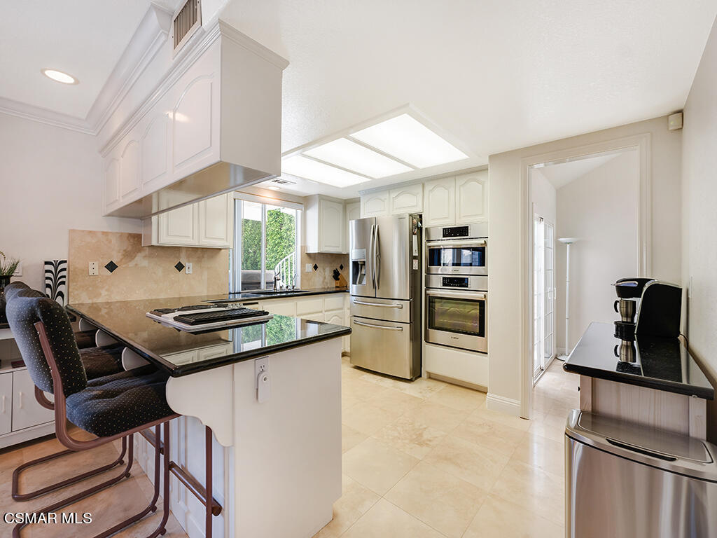 5218 Indian Hills Drive Simi Valley, CA 93063 - Photo 12 of 44 a kitchen with stainless steel appliances granite countertop a stove refrigerator and a sink