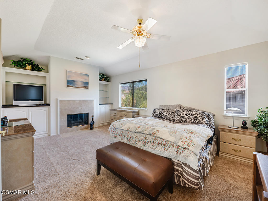 5218 Indian Hills Drive Simi Valley, CA 93063 - Photo 27 of 44 a bedroom with a large bed a flat tv screen and a fireplace