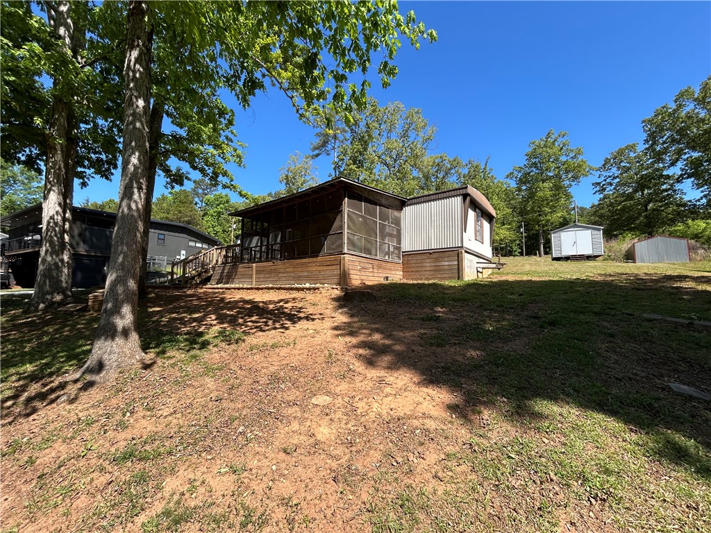 43 Sunset Cove Road Abbeville, SC 29620 - Photo 28 of 41 This property features ample outdoor space with mature trees and a charming screened porch.