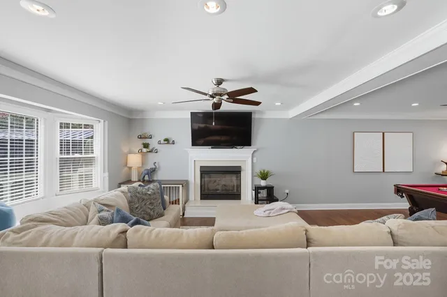 a living room with furniture a fireplace and a flat screen tv