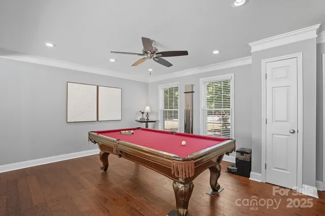 a room with pool table and windows