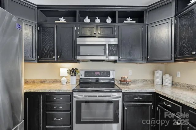 a kitchen with stainless steel appliances granite countertop a stove a microwave and cabinets