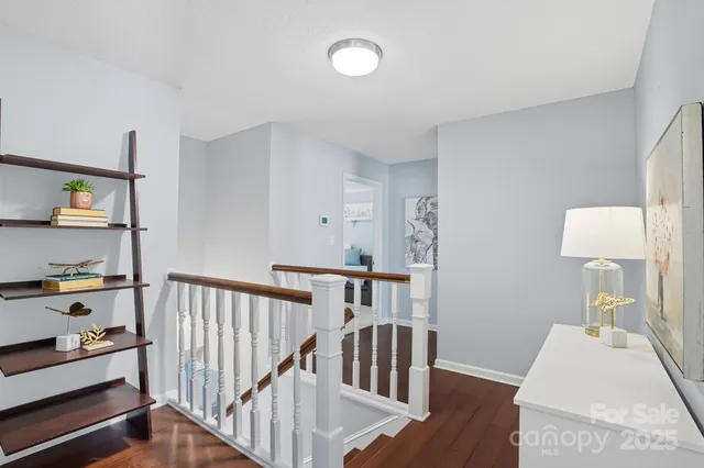 a view of a hallway with furniture and wooden floor