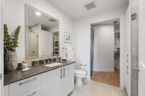 a bathroom with a granite countertop sink a toilet and a mirror