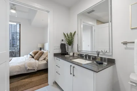 a bedroom with a sink and a mirror