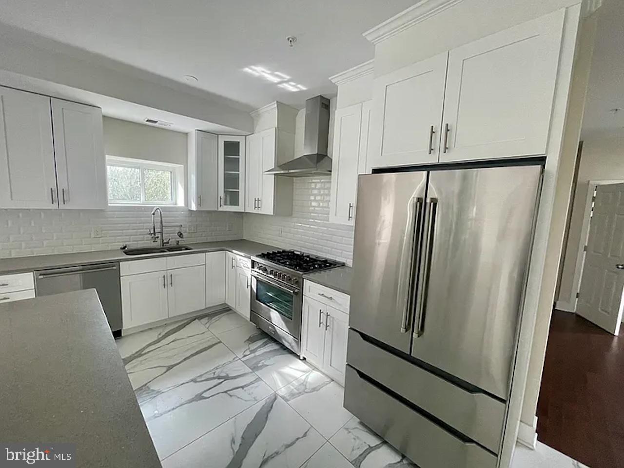 8618 Jones Mill Road Chevy Chase, MD 20815 - Photo 9 of 59 a kitchen with white cabinets and white appliances