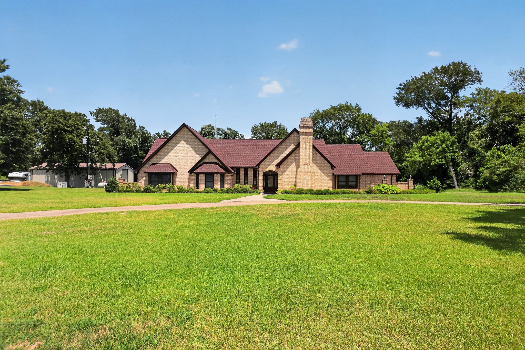 1950 Country Club Road Brenham, TX 77833 - Photo 8 of 39 A spacious front yard introduces this brick-clad ranch with a prominent chimney, inviting all to a serene dwelling.