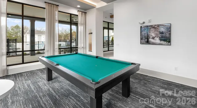 a room with pool table and windows