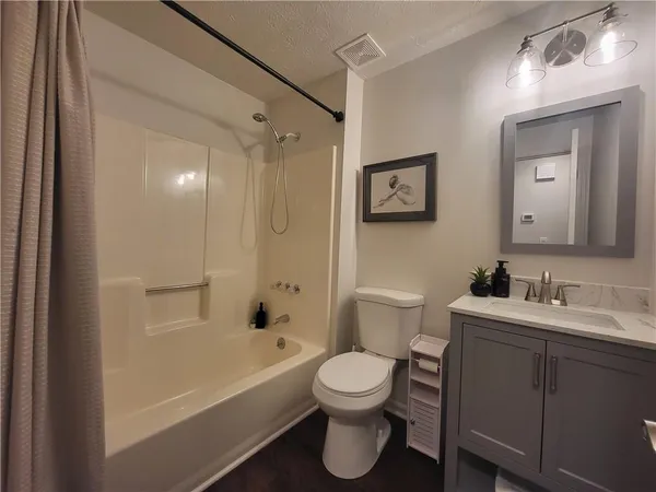a bathroom with a toilet sink vanity tub and shower
