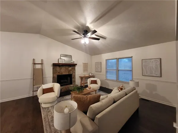 a living room with furniture a fireplace and a chandelier