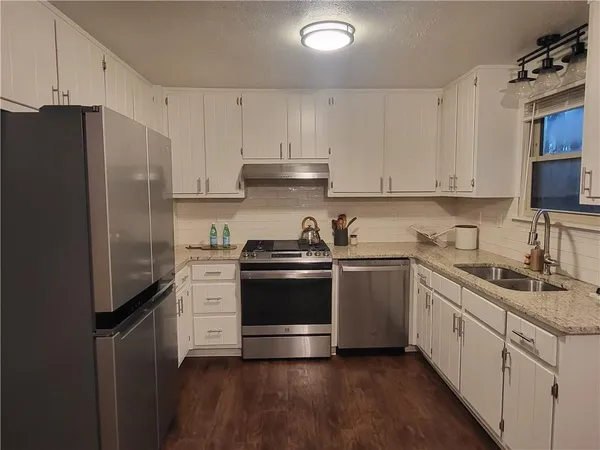a kitchen with stainless steel appliances white cabinets and a sink