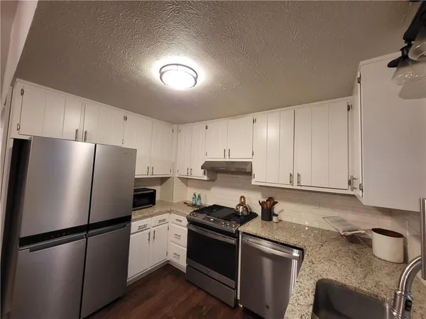 a kitchen with a refrigerator sink and cabinets