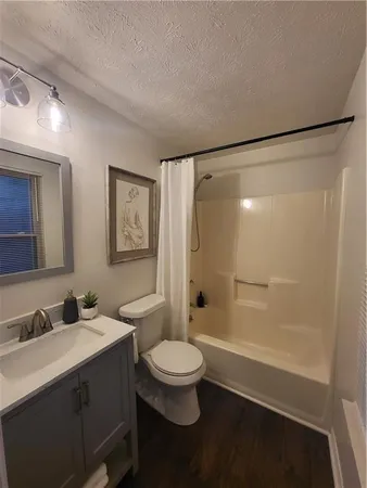 a bathroom with a double vanity sink toilet mirror and shower