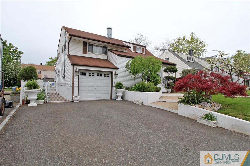 193 McFarlane Road Colonia, NJ 07067 - Photo 2 of 25 a front view of a house with a yard and garage