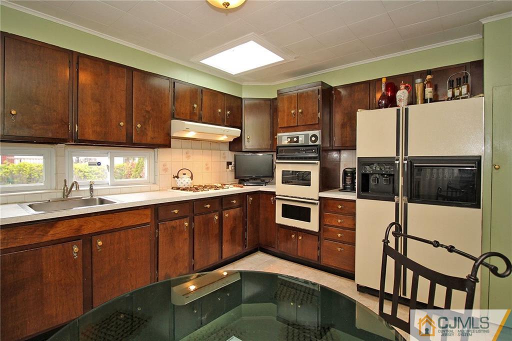 193 McFarlane Road Colonia, NJ 07067 - Photo 11 of 25 a kitchen with stainless steel appliances wooden cabinets and a sink