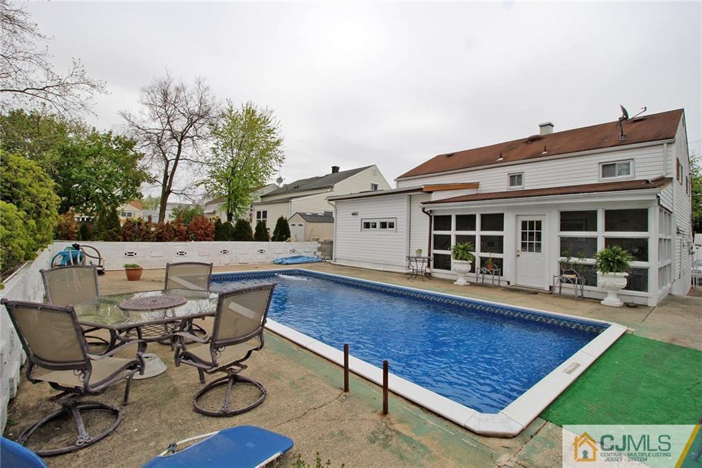 193 McFarlane Road Colonia, NJ 07067 - Photo 17 of 25 a view of a patio with table and chairs with wooden floor and fence