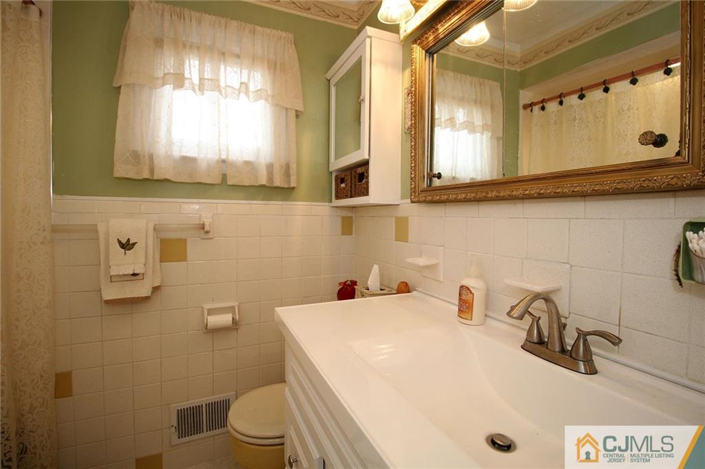 193 McFarlane Road Colonia, NJ 07067 - Photo 24 of 25 a bathroom with a sink a toilet and mirror