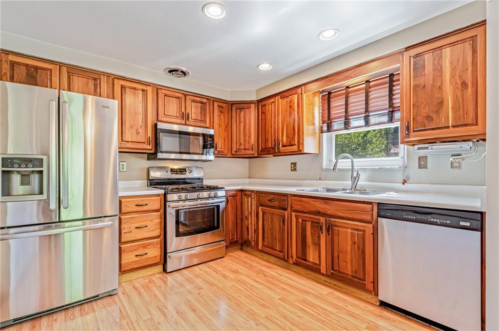 5000 Homeville Road West Mifflin, PA 15122 - Photo 6 of 24 a kitchen with stainless steel appliances granite countertop a refrigerator and wooden cabinets