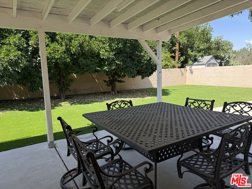 19023 Cantlay Street Reseda, CA 91335 - Photo 14 of 17 a view of a patio with table and chairs under an umbrella next to a yard