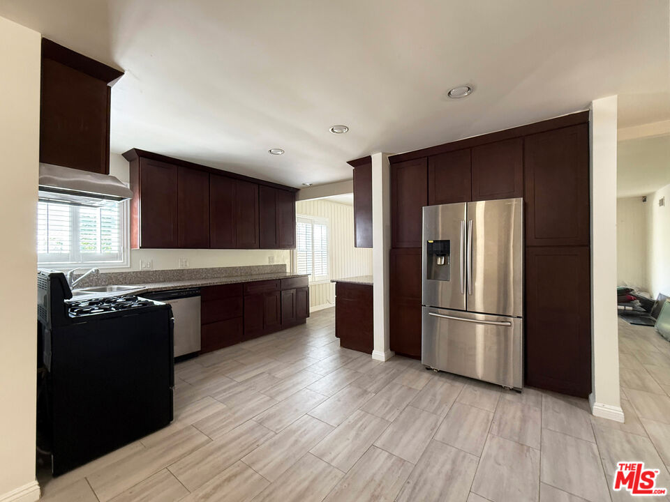 19023 Cantlay Street Reseda, CA 91335 - Photo 4 of 17 a kitchen with stainless steel appliances granite countertop a refrigerator a sink and wooden floor