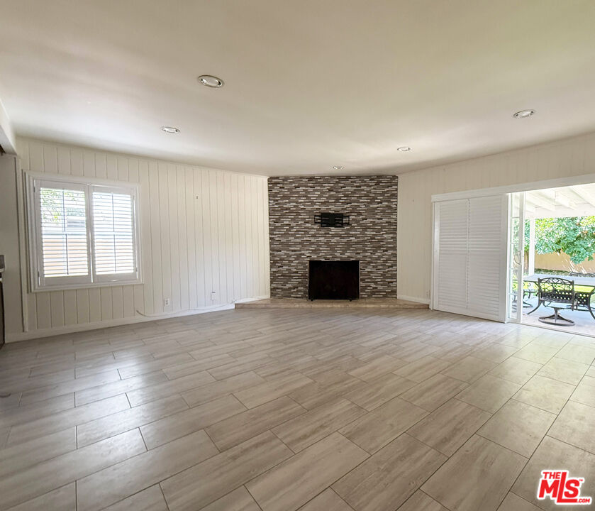 19023 Cantlay Street Reseda, CA 91335 - Photo 6 of 17 an empty room with floor to ceiling window and fireplace