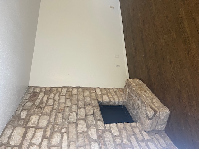 501 Hedgewood Drive, Unit D Georgetown, TX 78628 - Photo 2 of 15 Unfurnished living room featuring wood finished floors, a large fireplace, and a textured ceiling