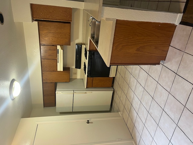 501 Hedgewood Drive, Unit D Georgetown, TX 78628 - Photo 5 of 15 Kitchen with gas stove, light countertops, fridge, a textured ceiling, and extractor fan