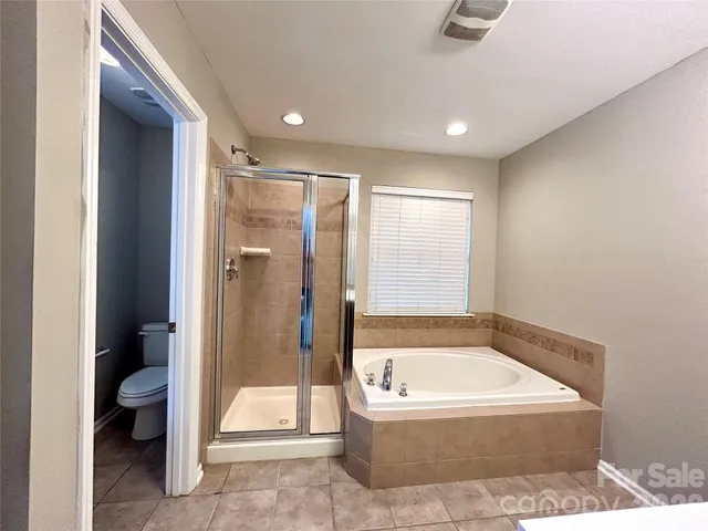 a bathroom with a tub a toilet and a shower