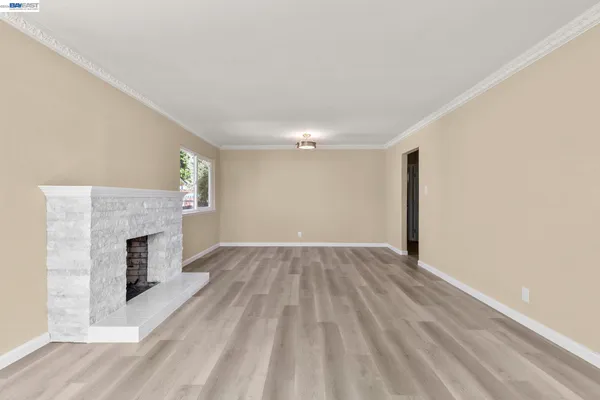 a view of empty room with wooden floor and fireplace