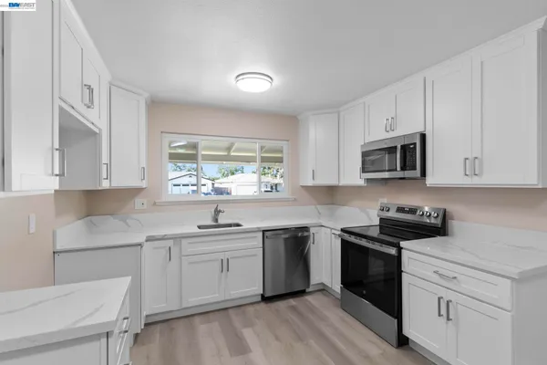 a kitchen with a sink white cabinets and appliances