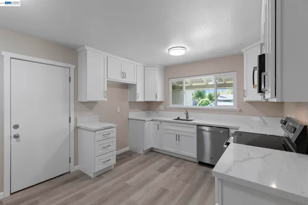 a kitchen with stainless steel appliances sink stove refrigerator and cabinets