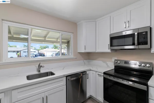 a kitchen with appliances a sink and cabinets